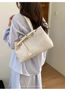Retro cream minimalist shoulder bag on model showing size and sophisticated style