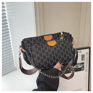 Three-in-one crossbody bag featuring black monogram pattern with gold hardware details