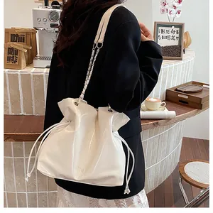 Sac seau en cuir verni blanc avec cordon de serrage et détail de bandoulière chaîne
