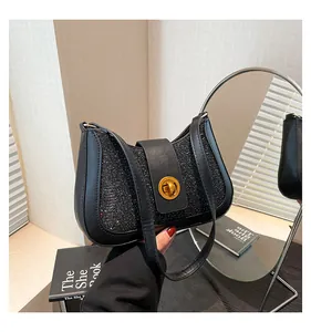 Close-up of black sequined underarm bag with golden twist lock and sleek leather straps
