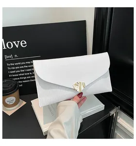 Detailansicht der weißen Umschlag-Clutch mit Wellentextur und goldener Schnalle