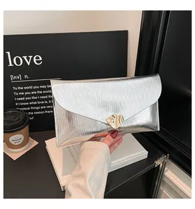 Detailansicht der silbernen Umschlagtasche mit Faltenstruktur und goldener Metallschnalle