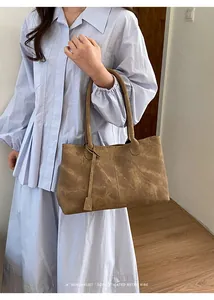 Close-up of retro brown marbled tote bag worn with a light blue pleated dress