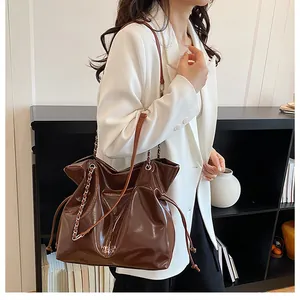 Sac fourre-tout marron brillant avec bandoulière chaîne et imprimé London sur modèle