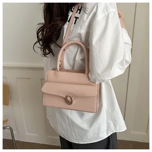 Detail of light pink lychee pattern faux leather handbag with metallic oval lock