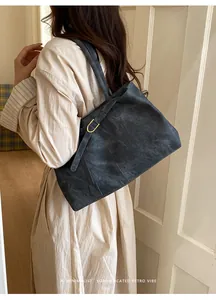 Detail of dark grey retro tote bag featuring soft suede texture and gold D-ring hardware
