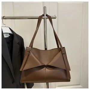 Détail du sac cabas marron mat avec pli géométrique et boucle en métal argenté