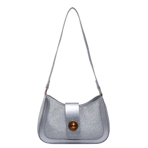 Minimalist silver metallic underarm bag for women featuring a golden round swivel lock