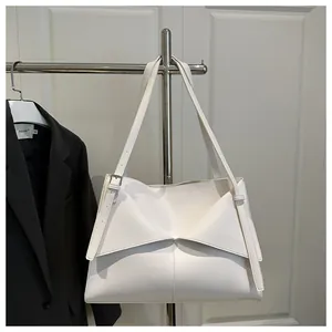 Gros plan d'un sac cabas blanc en cuir avec détails de rabats triangulaires superposés