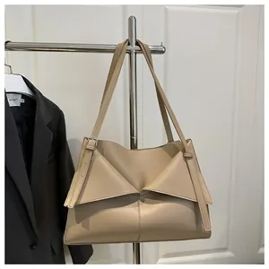 Détail du sac beige avec design géométrique plié et bandoulière en cuir ajustable
