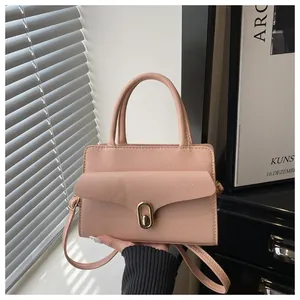 Detail of pink lychee leather crossbody bag with elegant gold oval twist lock closure