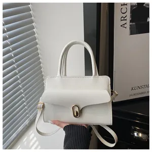 Detailed close-up of cream square bag featuring lychee grain texture and gold swivel lock