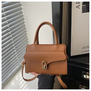 Detail of caramel leather bag with lychee texture and golden oval twist lock