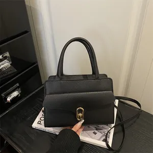 Retro black leather top-handle square bag with gold oval twist lock and slim strap