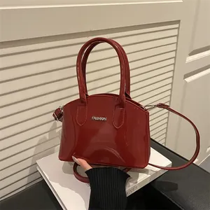 Deep red patent leather shell bag with top handles and fashion logo for women