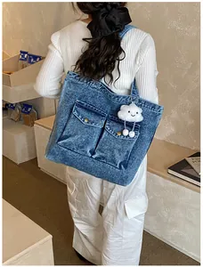 Blue denim tote bag detail featuring retro metal buckles and a cute cloud plush charm