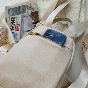 Elegant off-white lychee pattern leather mini backpack with golden zippers on tweed fabric