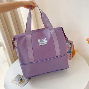 Detail view of purple waterproof travel bag with bottom compartment and square logo patch