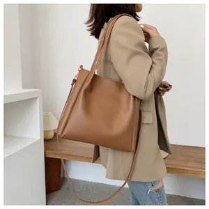 Caramel large tote bag in smooth PU leather shown with shoulder strap on a model