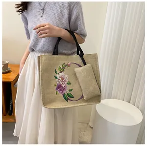 Detailansicht der beigen Leinentasche mit lila Blumenmuster und kleinem Anhänger