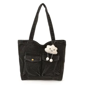 Large gray washed denim tote bag with front pockets and white cloud plush pendant charm