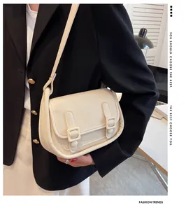 French retro cream leather shoulder bag with decorative buckle straps on model
