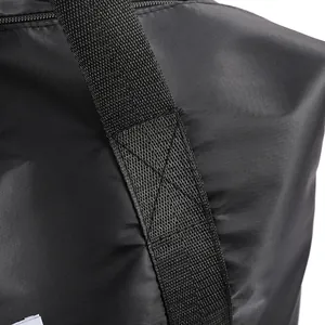 Detail of reinforced cross-stitching on black waterproof travel bag handles