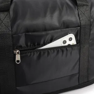 Detail of water-resistant black nylon travel bag with side zipper pocket for phone storage