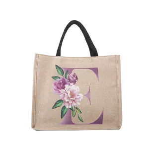 Ins-Style Jute-Einkaufstasche mit schwarzen Griffen und violettem Blumen-Buchstaben E