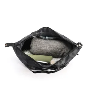 Top view of spacious interior of black travel bag with organized clothes and accessories