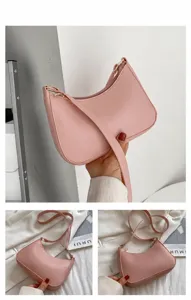 Detail van roze halve maan tas met litchi-textuur en goudkleurige ritssluiting