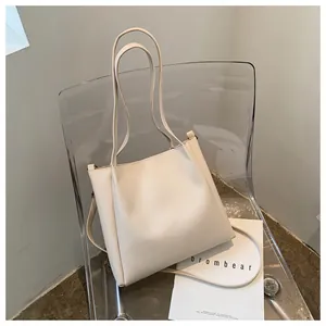 Detail of off-white minimalist tote bag in PU leather on a modern chair