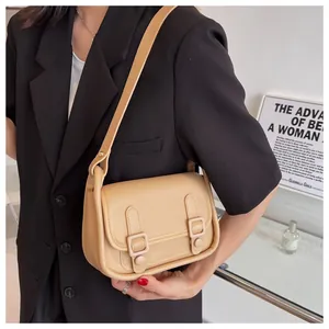Asian model wearing a light khaki leather shoulder bag with metallic buckle closure