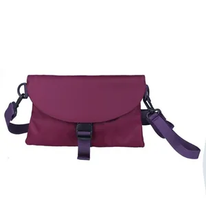 Détail de la sacoche en nylon violet foncé avec boucle en plastique noir et bandoulière réglable