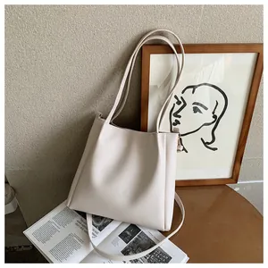 Detailed close-up of cream-white tote bag on wooden table with elegant interior props