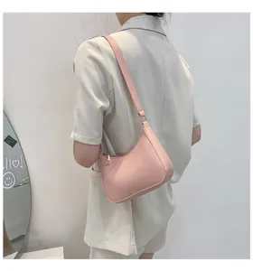 Chic light pink hobo bag shown on shoulder of a model for size and silhouette