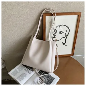 Detail view of beige PU leather tote bag with slim handles and adjustable shoulder strap