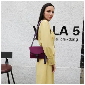Détail du sac bandoulière en nylon violet avec boucle porté sur une robe jaune
