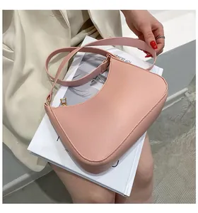Detail of pink semi-circular shoulder bag with textured leather and gold zipper
