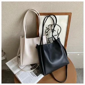Detail of minimalist tote bags in cream and black with adjustable shoulder straps