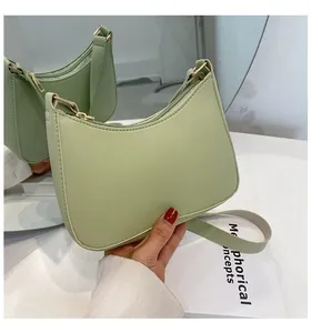 Detail of light mint green crescent underarm bag with lychee texture and gold zipper