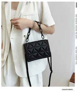 Detail of black quilted crossbody bag featuring acrylic chain and sleek rhombic pattern