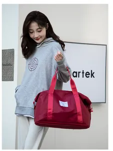 Outdoor lifestyle shot of a red large capacity travel bag with double handles