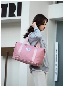 Pink waterproof travel bag with bottom zipper compartment and crossbody strap