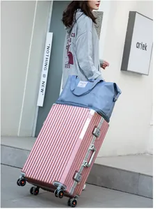 Detail of blue travel bag attached to pink suitcase handle for dry and wet separation