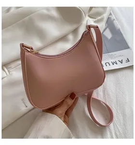 Close-up of light pink PU leather handbag with matte lychee texture and gold zipper detail