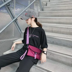 Sac bandoulière en nylon fuchsia avec boucle violette sur fond d'escalier urbain