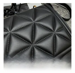 Detail shot of black quilted faux leather crossbody bag with chunky acrylic chain strap