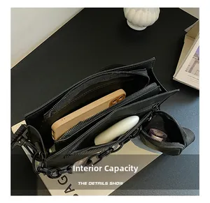 Internal capacity of black crossbody bag showing phone and lipstick in main pocket