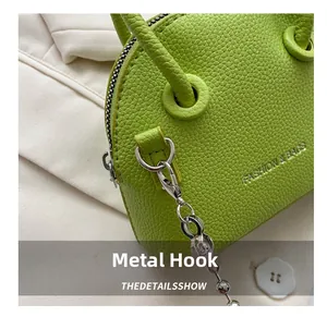 Detail of lime green lychee pattern mini shell bag with silver hardware and hook